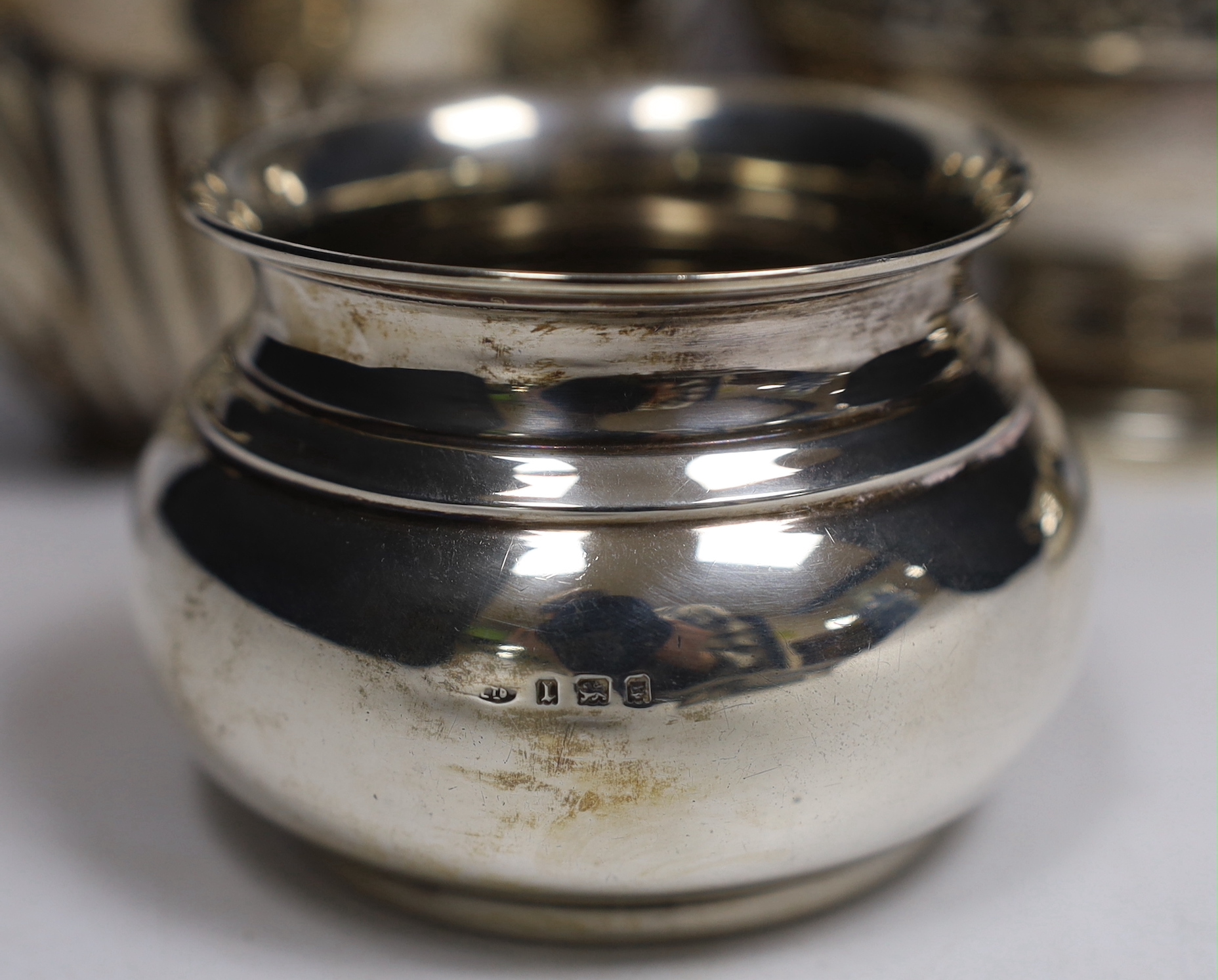 A late Victorian demi fluted silver oval teapot, John Round, Sheffield, 1897, a later silver hot water pot by Elkington & Co and a silver cream jug and sugar bowl, gross weight 28.5oz.